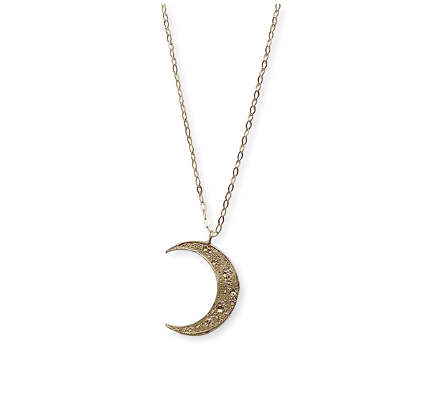 Gold crescent moon necklace on a white background
