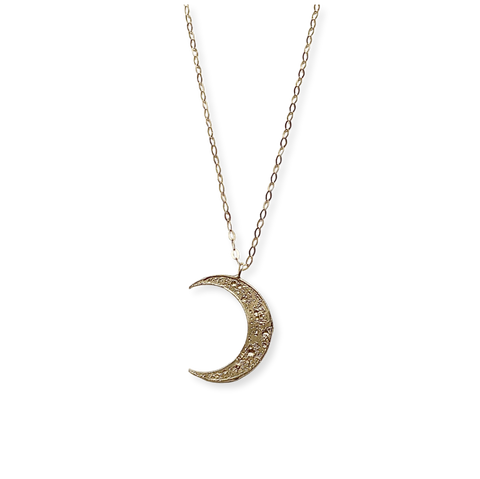 Gold crescent moon necklace on a white background