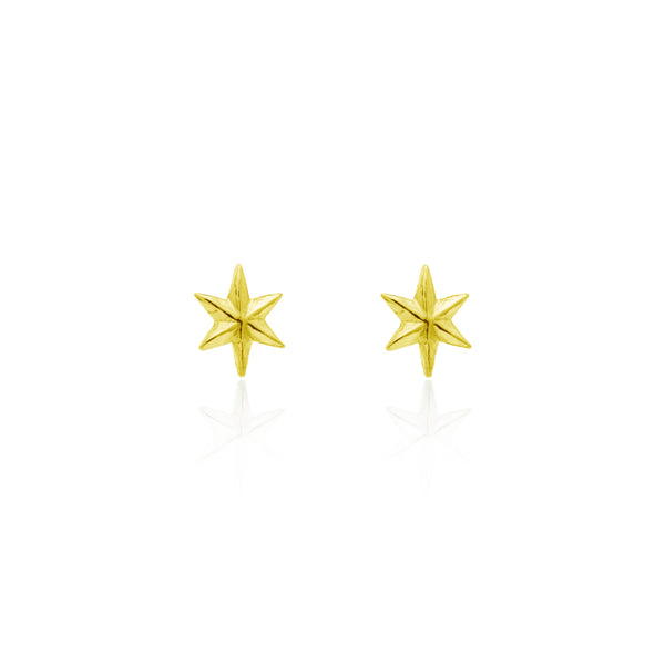 A pair of tiny gold star stud earrings against a white background.