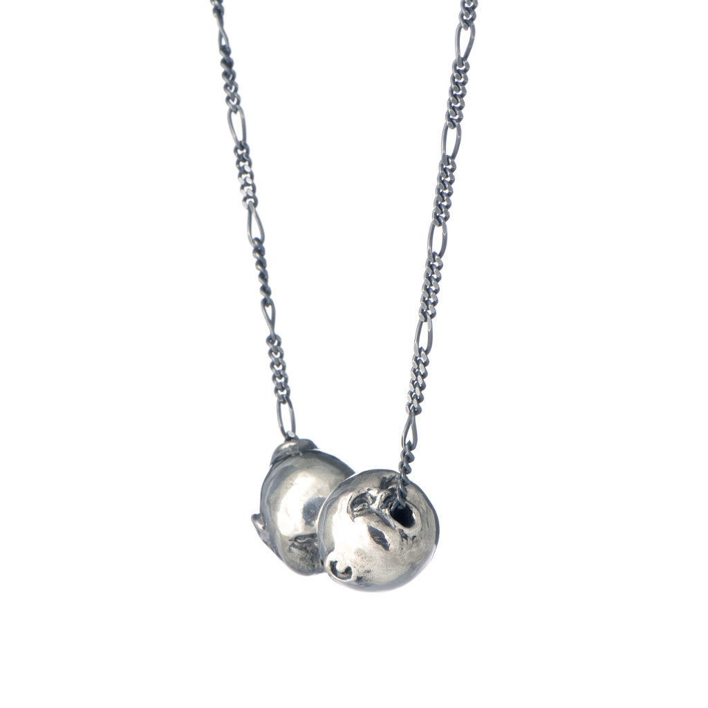A recycled sterling silver double face pendant from 'The Secret Garden' collection with a figaro chain go go through the balls